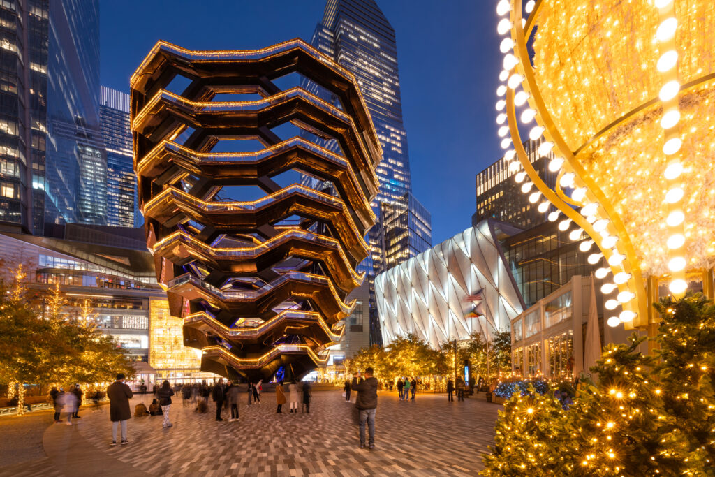 Hudson Yards exterior illuminated with white lights and hot air balloons.